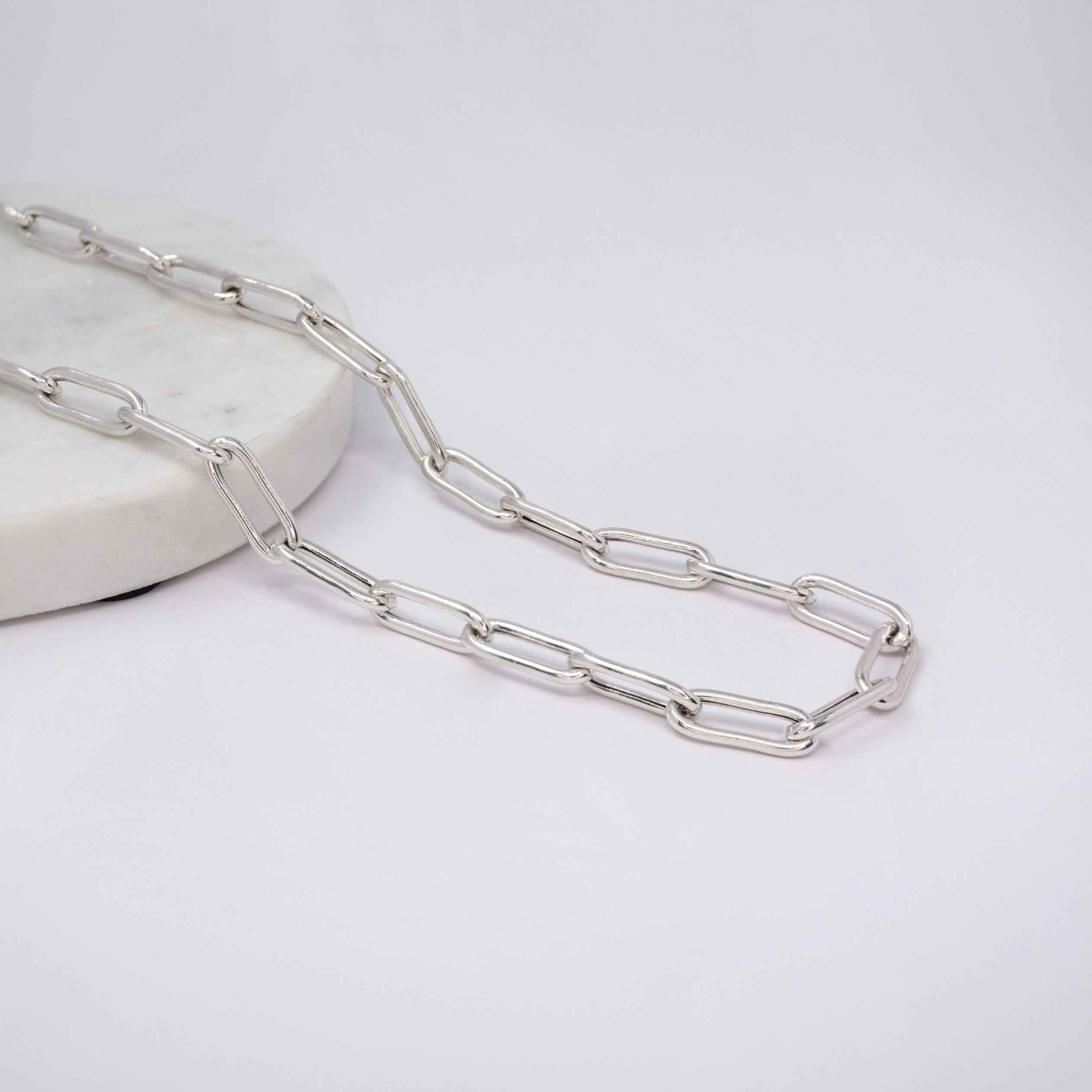 Silver Paperclip chain necklace on a light gray background