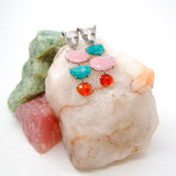 Leopard face earrings set with colorful stones on a stone surface