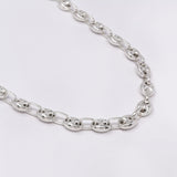 Silver chain necklace on a light gray background