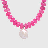 Close-up of the wonky pearl drop hanging from a silver bail between vibrant pink agate beads