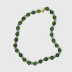 Necklace with blue and green beads on a light gray background