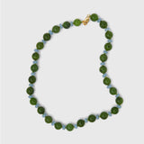 Necklace with blue and green beads on a light gray background