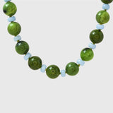 Necklace with green and light blue beads on a white background