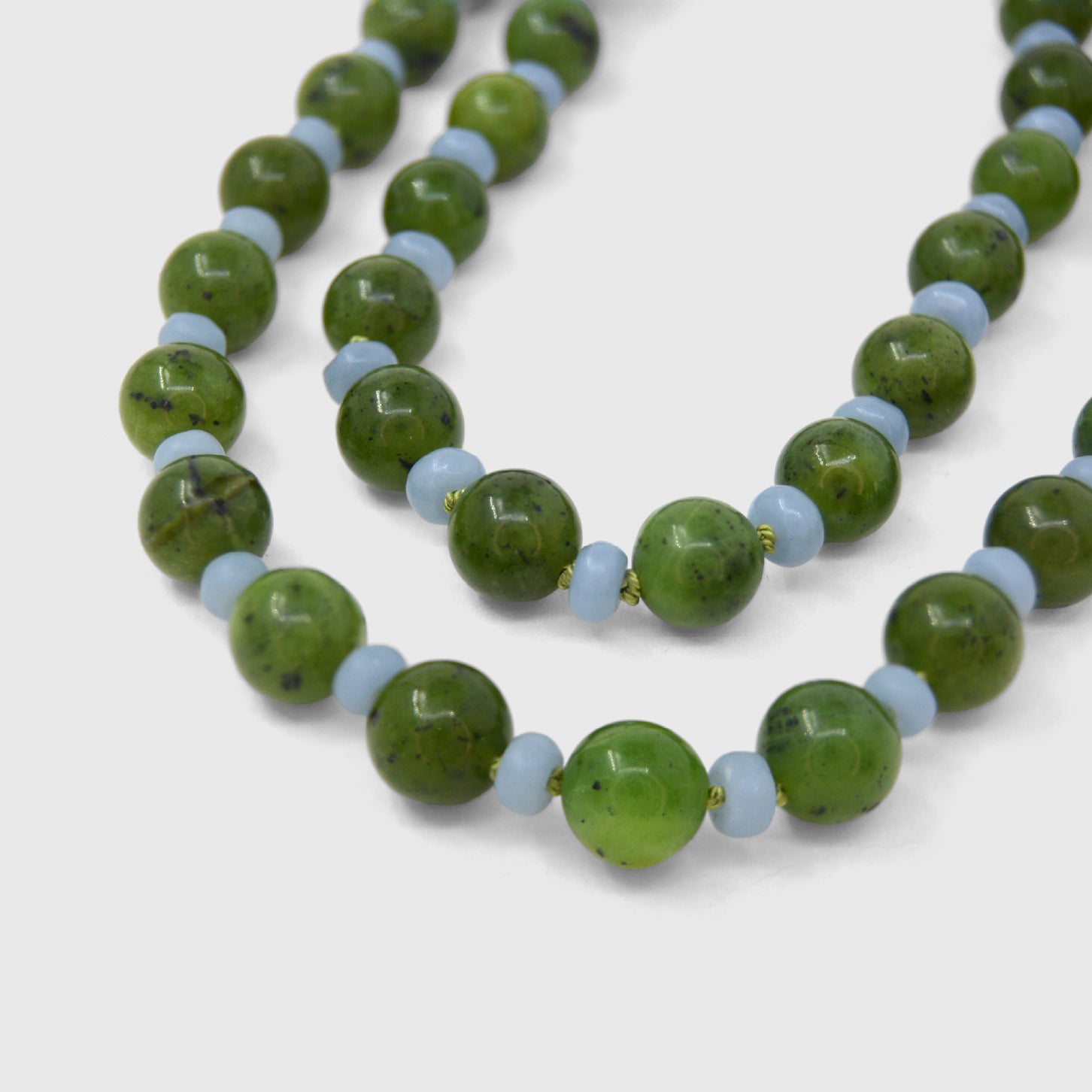 Necklace with green and light blue beads on a white background