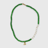jade beaded necklace with a gold clasp and initial pendant on a light grey background