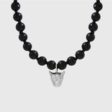 Black beaded necklace with a silver leopard face pendant on a white background