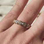 Cushion-cut lab-grown diamond wedding band in 9ct yellow gold, shown on the hand and held up to the light