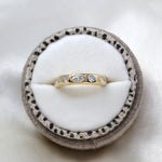 Truly marquise and round lab-grown diamond wedding band in 9ct yellow gold in a speckled linen ring box, viewed from the top